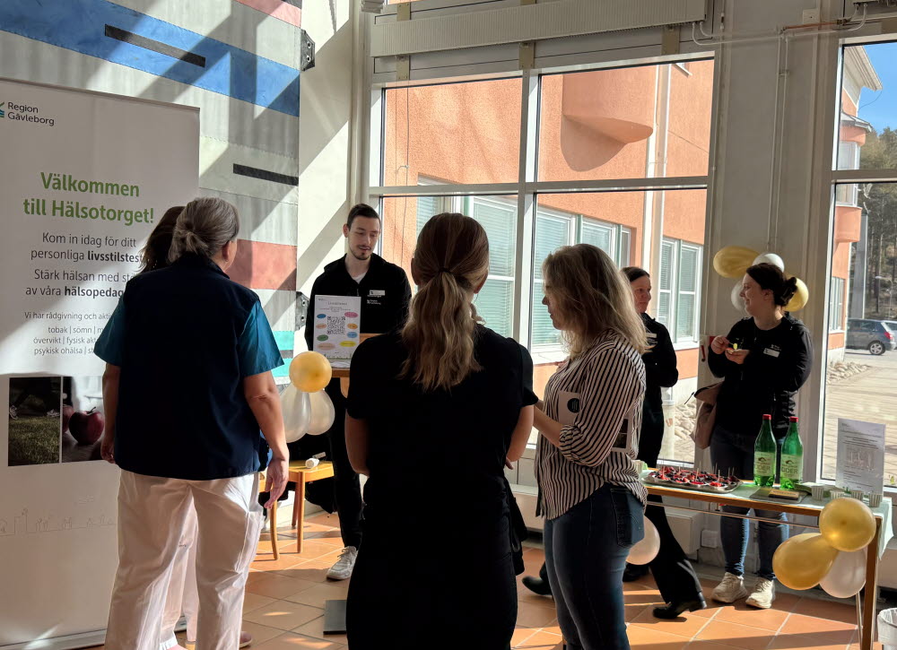 Flera personer står i en stor byggnad inne.