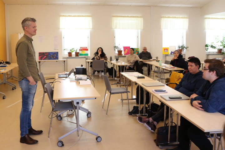 Lärare står framför kursdeltagare som sitter i klassrum