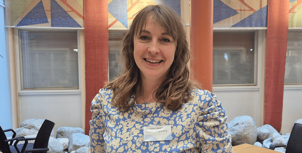 En kvinna sitter vid ett bord med en tallrik med mat.