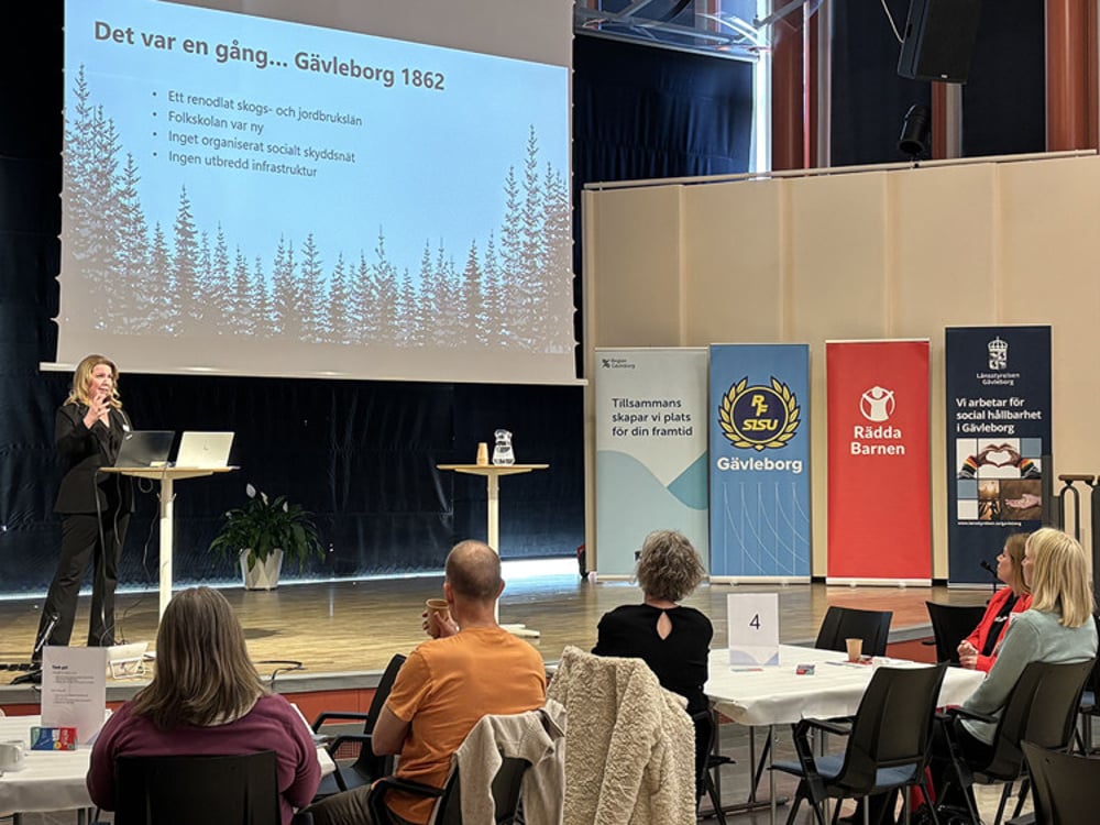 En kvinna som håller en presentation för en grupp människor.