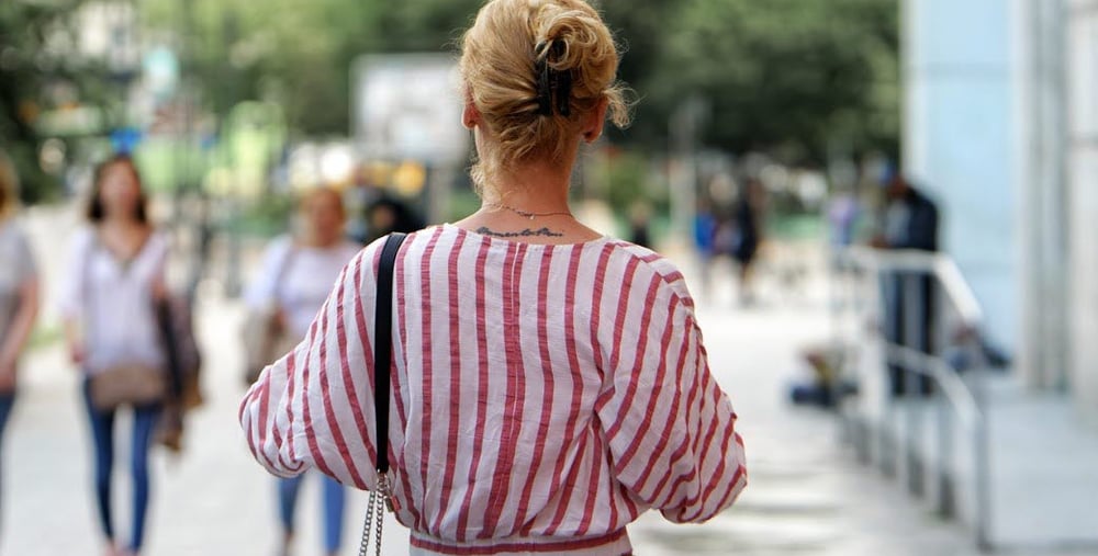 Kvinna som står på en gata bakifrån