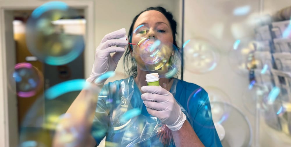 Barnsköterska Emma Good blåser såpbubblor. 