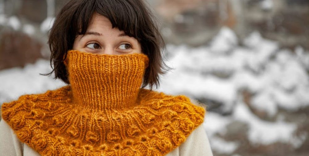 Kvinna med stickad halsduk utomhus