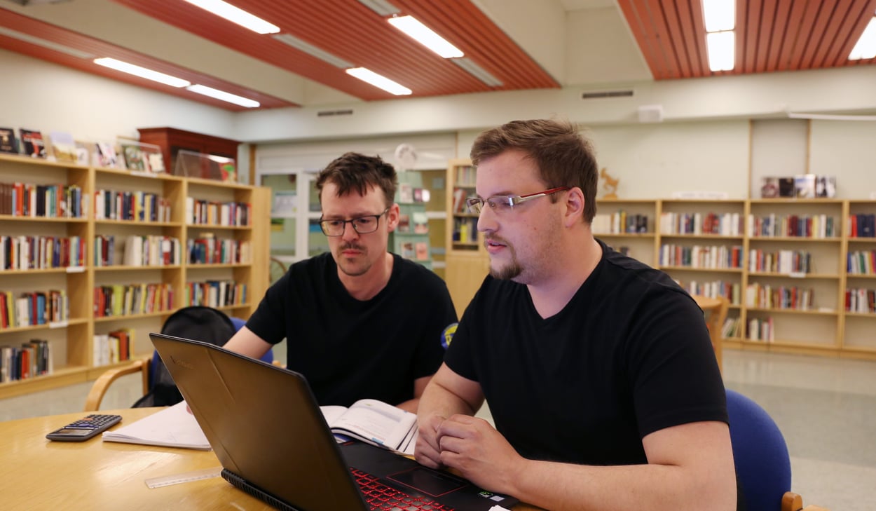 Två kursdeltagare sitter och studerar