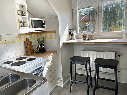 Ett k&ouml;k med en spis med ugn bredvid en diskho.