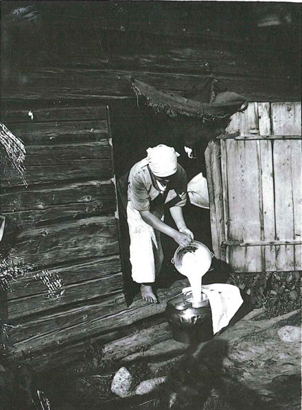 Ett svartvitt foto av en person som häller upp mjölk.