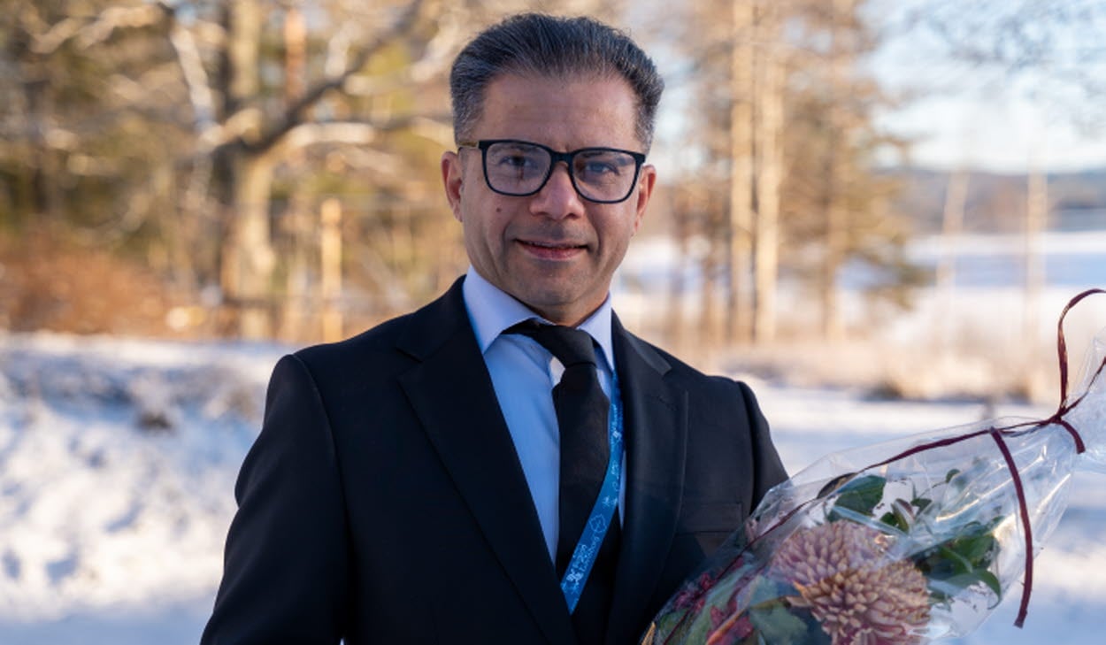 Årets medarbetare, Porträtt av en person i kostym som håller en bukett blommor utomhus i vintermiljö